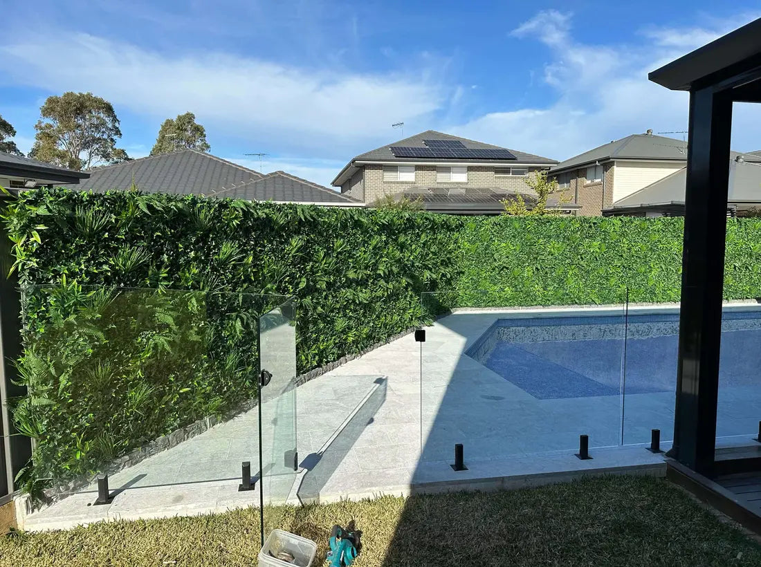 Artificial green privacy hedge wall around residential pool area