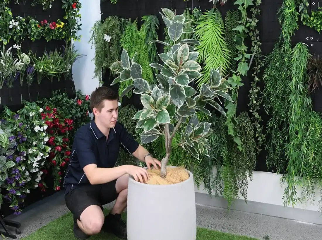 putting fiber into the pot with the faux plant