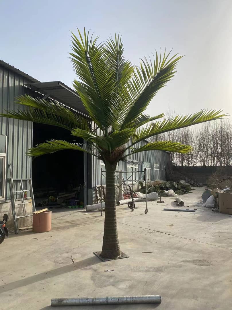 Artificial palm tree in an outdoor setting with a building in the background
