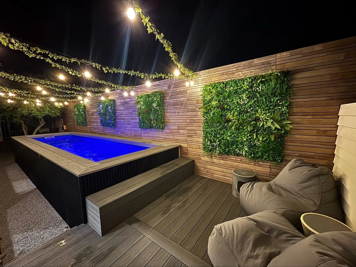 Modern outdoor deck with pool, string lights, vertical garden walls, and cozy beanbag seating.