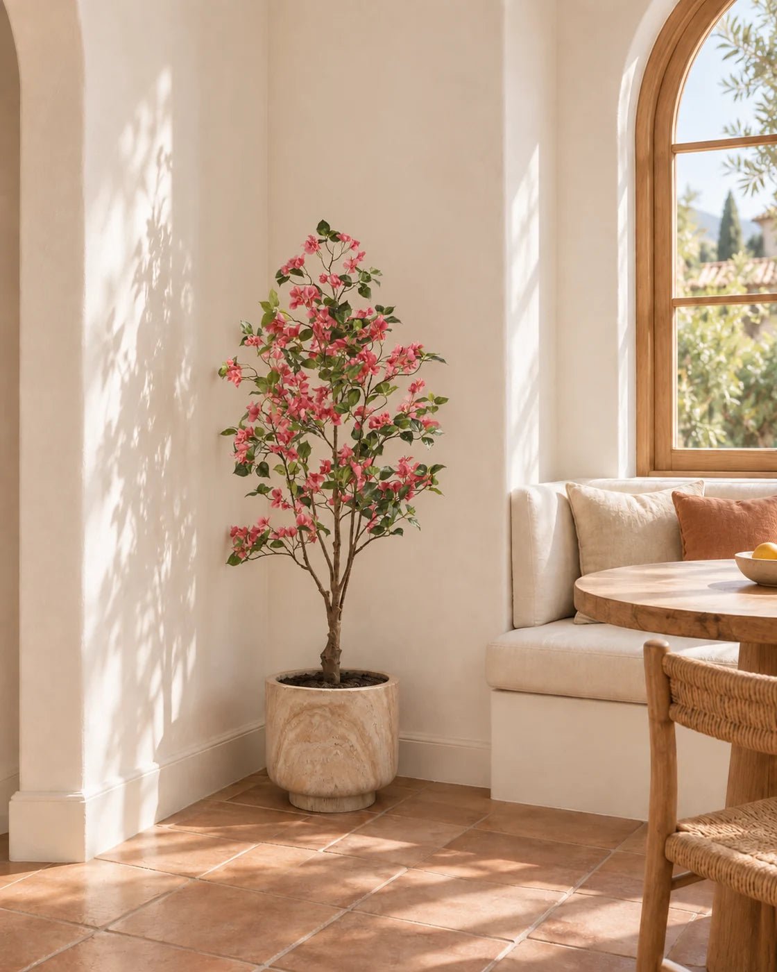 150 cm artificial pink Bougainvillea in a marble-effect pedestal planter tucked beside a Mediterranean-style breakfast nook.