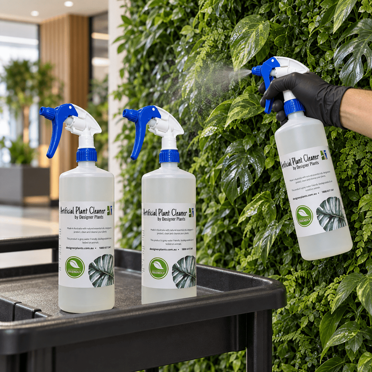 Set of three Eco Home Safe artificial plant cleaner bottles used on an indoor green wall