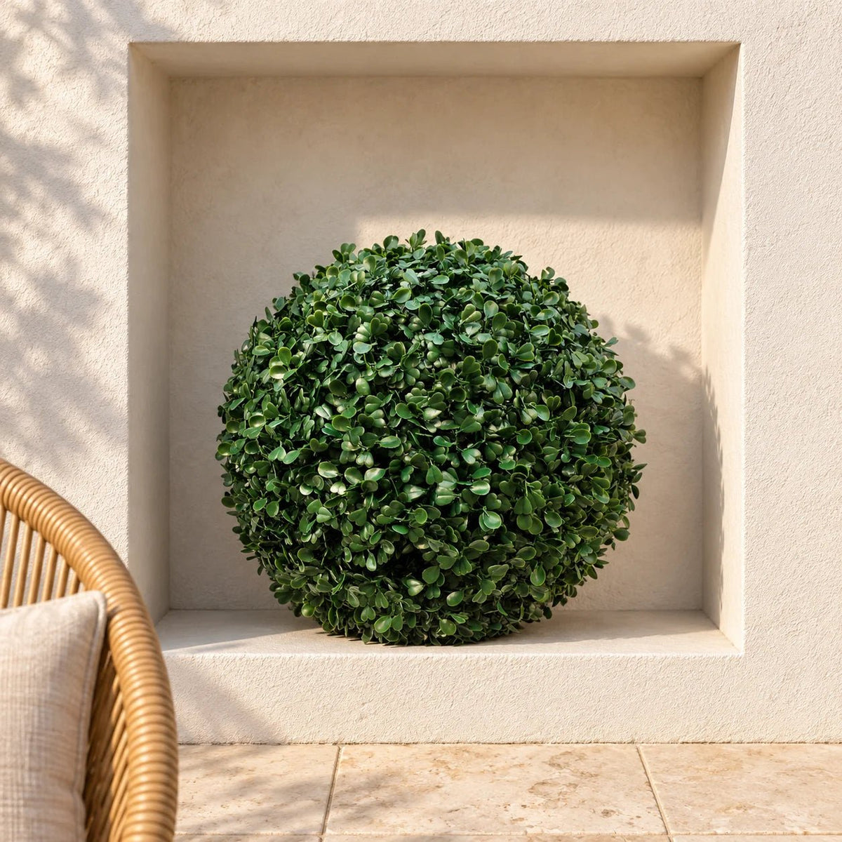 Artificial boxwood topiary ball in a square courtyard niche