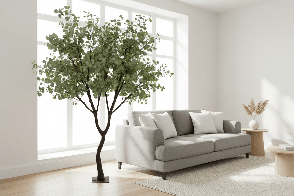 Living room with a gray sofa, decorative plant, and small table.