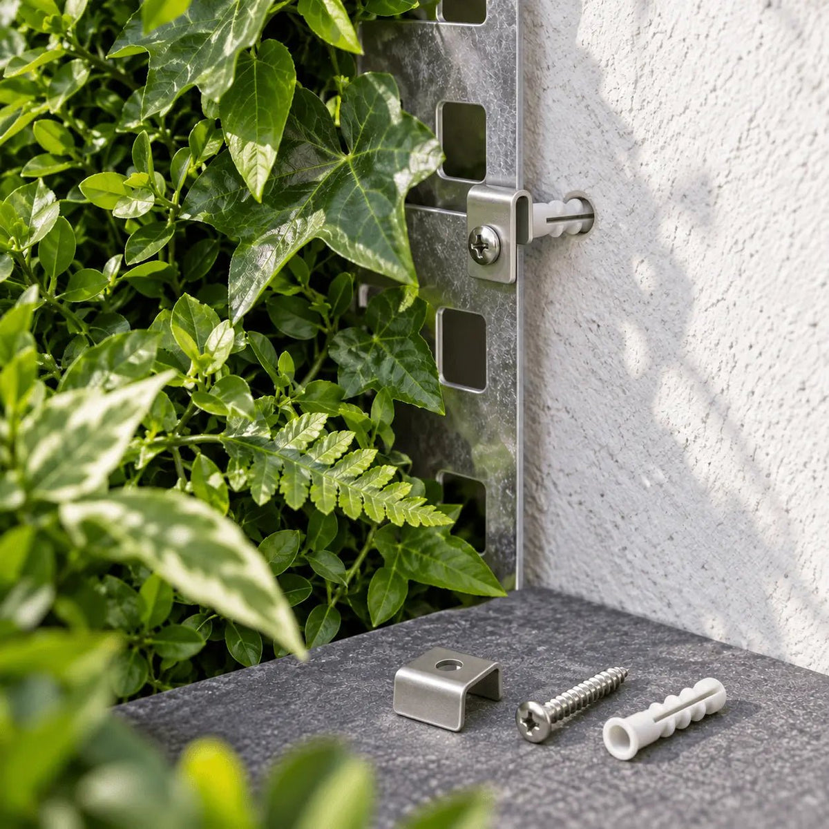 U-shaped metal clip, screw and wall plug securing a metal-backed artificial green wall panel