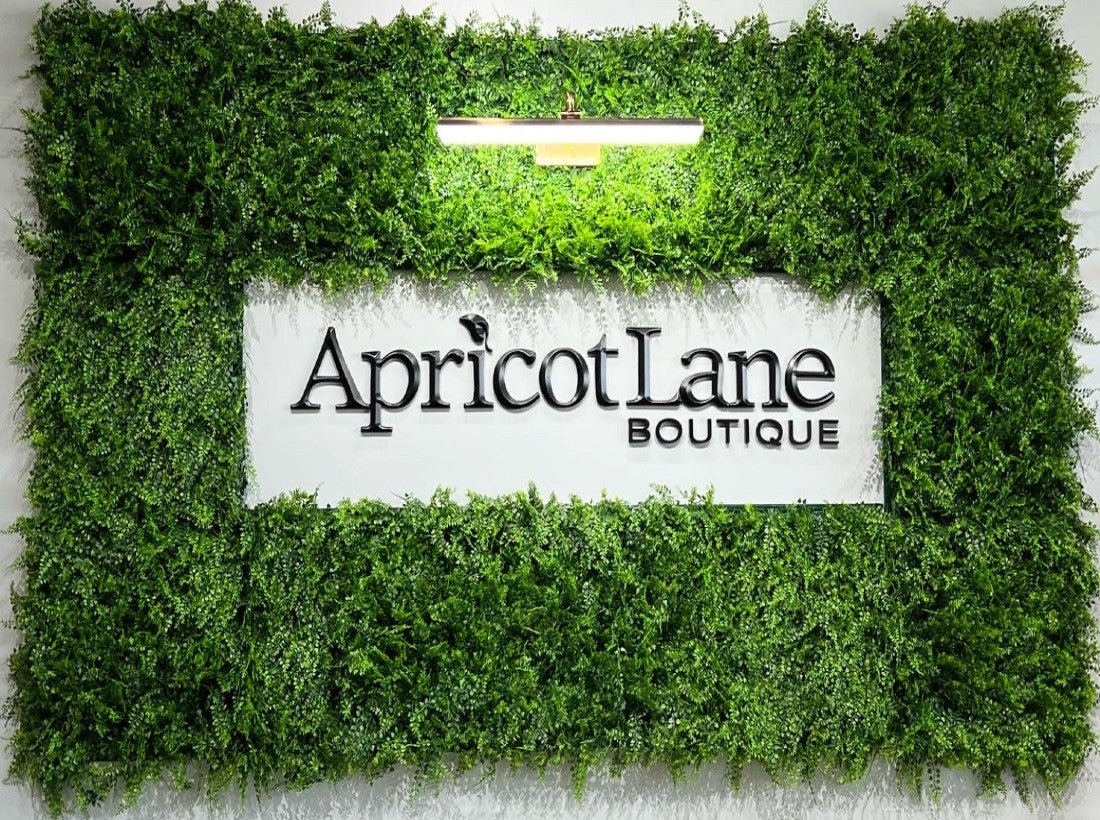Apricot Lane obtiene un letrero comercial personalizado con una pared verde falsa