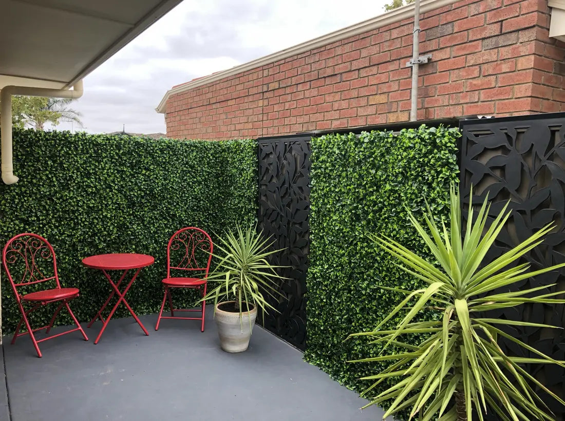 backyard place with artificial green walls potted plants chairs and table