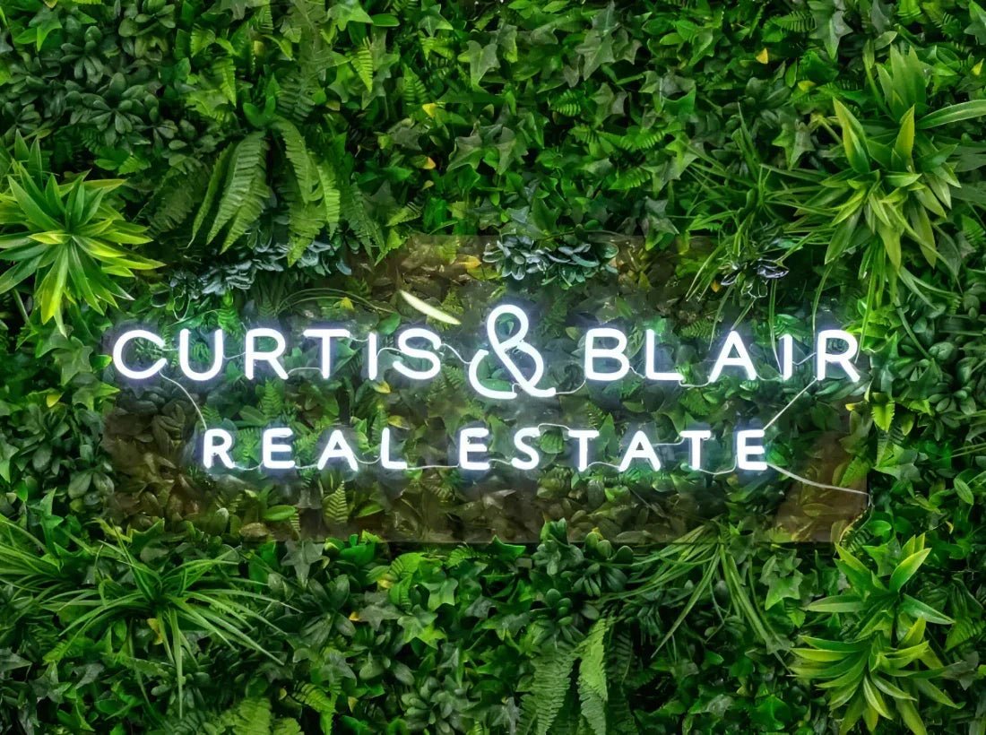 Real estate agency signage on artificial green wall