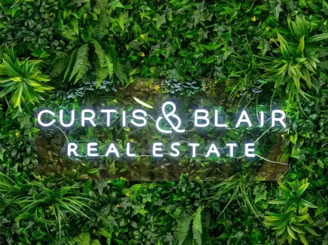 Real estate agency signage on artificial green wall