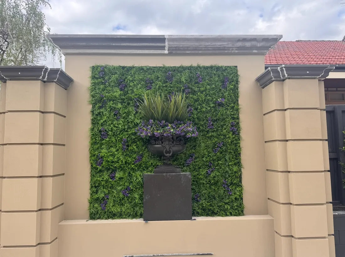 Vertical garden panel with purple floral accents mounted on exterior wall