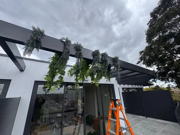 Artificial hanging greenery installed on modern balcony beams