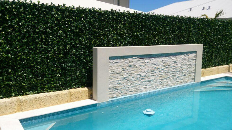 Artificial Hedge Panels Along a Pool Fence Wall