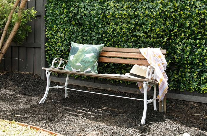 Artificial Large Ficus Leaf Hedge Panel along a timber fence and outdoor chair