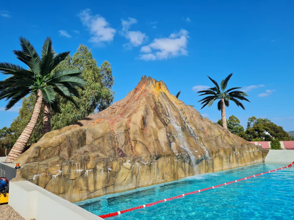 Commercial artificial palm trees surrounding a resort swimming pool area