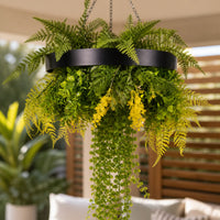 Close-up of a black framed artificial roof hanging disc featuring draping green vines, fern foliage, and yellow floral accents with UV resistant greenery.
