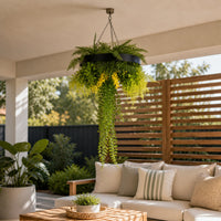 Black framed artificial hanging plant disc with cascading greenery and life-like foliage displayed in a modern covered outdoor patio with UV resistant plants.
