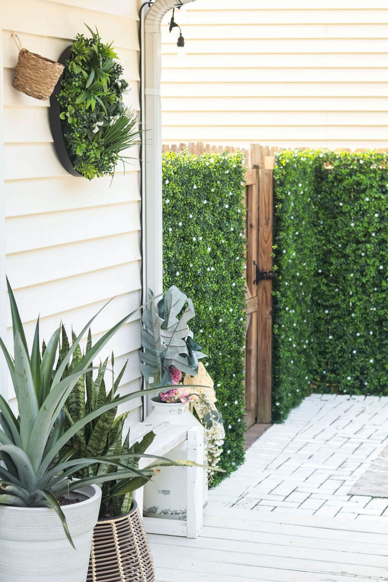 Artificial Boxwood Mat with Faux Flowers Installed Outdoors onto a Fence Backyard Renovation California