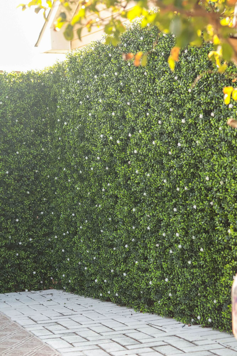 Artificial Boxwood Mat with Faux Flowers Installed Outdoors onto a Fence to enhance privacy