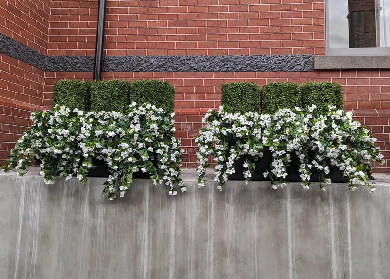 Two (5 Pieces) Hanging White Artificial Bougainvillea Plant UV Resistant 35" flower boxes on the side of a brick building.