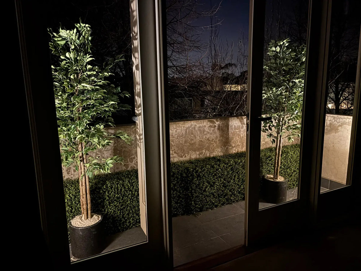 Luxury Deluxe Portable Buxus (Bright) UV Resistant 100cm Long x 50cm High, featuring dense, lush green artificial buxus foliage in a sleek black planter, displayed outdoors in a landscaped garden setting.