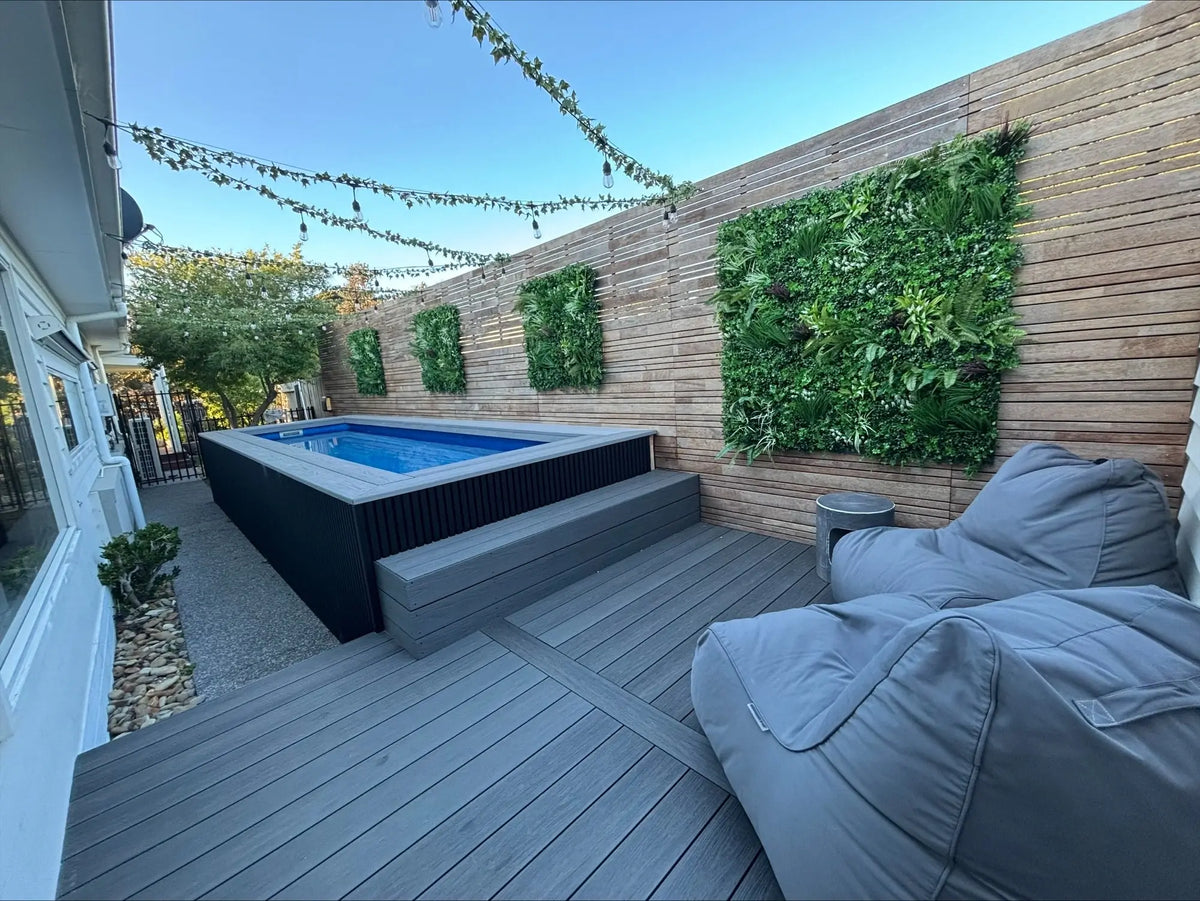 Modern backyard with above-ground pool, vertical garden wall, and outdoor bean bag seating.