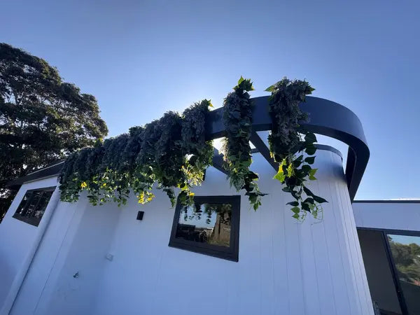 Uv resistant artificial hanging greenery on curved balcony beams