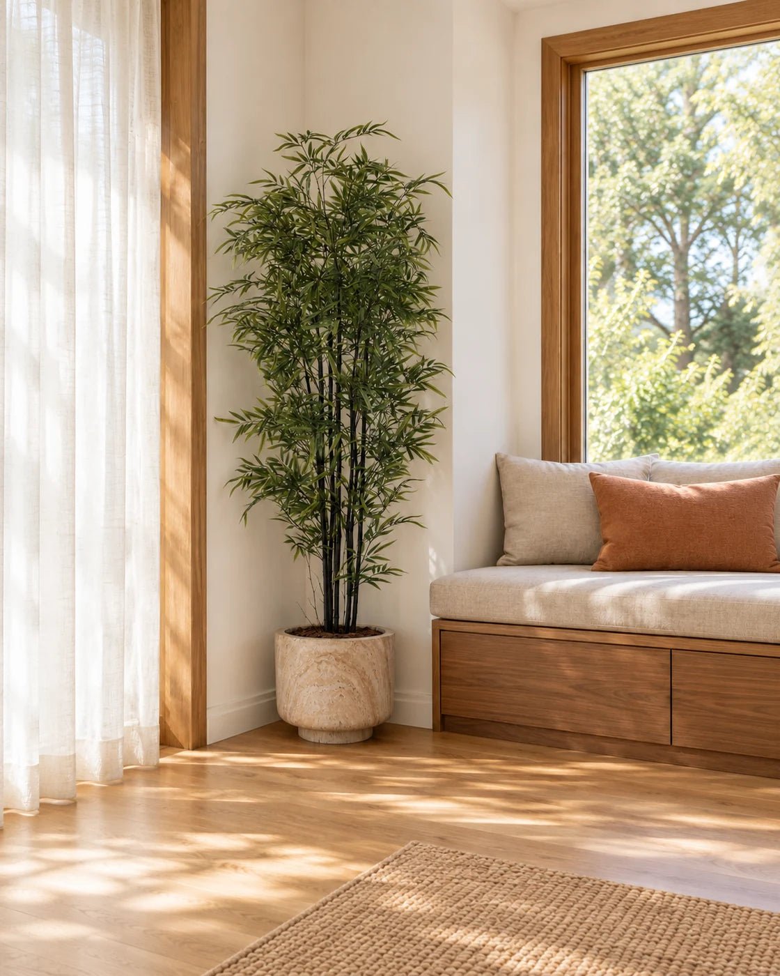 180 cm artificial Black Bamboo in a marble-effect pedestal planter tucked beside a built-in window seat in a sunny reading nook.