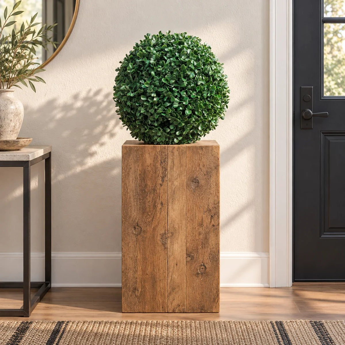Artificial boxwood topiary ball on a timber plinth in a residential entryway
