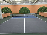 Indoor pickleball playing field with circle green wall in background.