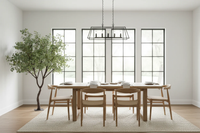 Dining room with wooden table and chairs, large windows, and a tree.