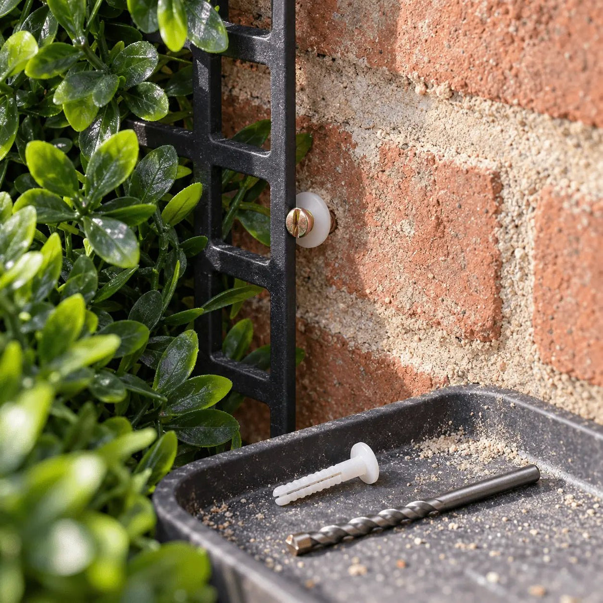 Nylon masonry plug and drill bit installation for an artificial green wall panel on brick