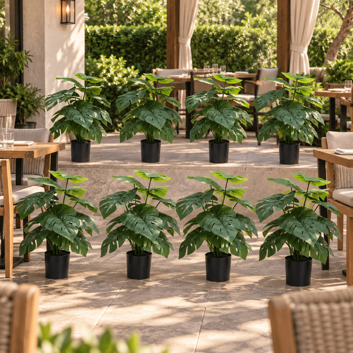 Set of eight 20-inch UV-resistant potted Monstera artificial plants on a covered outdoor restaurant patio