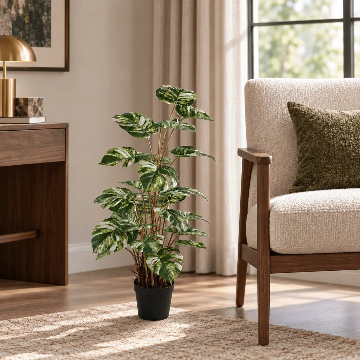 35.4-inch variegated Monstera Deliciosa artificial tree in its black nursery pot beside an indoor lounge chair