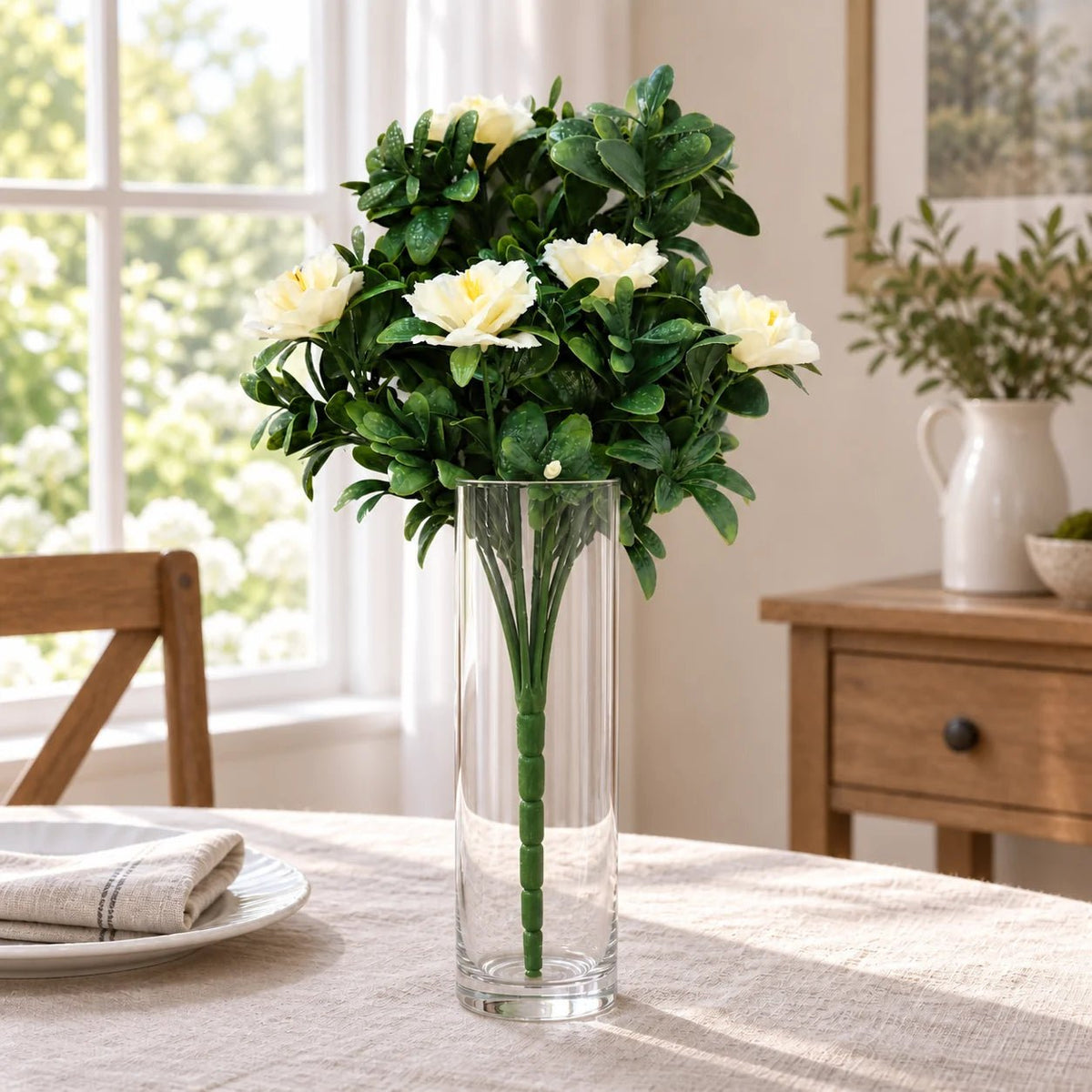 White artificial rose bunch in a clear vase on a dining table