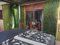 Natural artificial boxwood hedge panel installed onto a deck